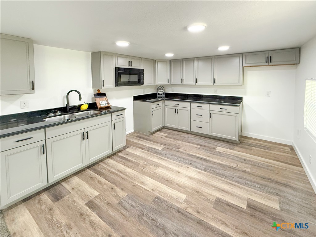 215 East Valley Road Harker Heights, TX 76548 - Photo 4 of 16 a kitchen with granite countertop white cabinets and stainless steel appliances