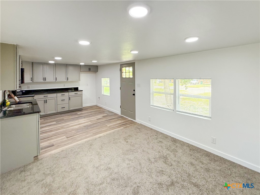 215 East Valley Road Harker Heights, TX 76548 - Photo 7 of 16 a large kitchen with kitchen island a stove a sink a refrigerator and blue cabinets with wooden floor
