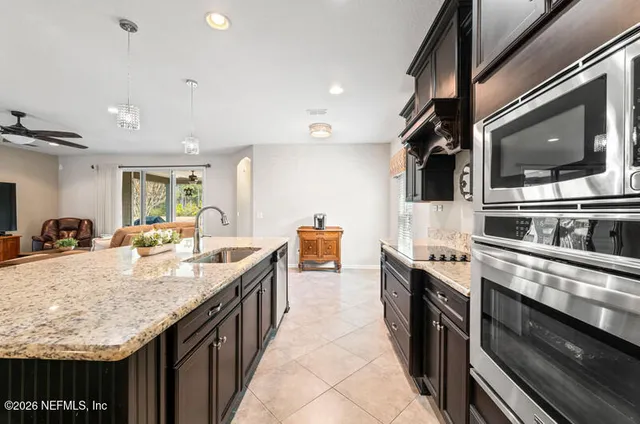 a large kitchen with granite countertop a sink and cabinets