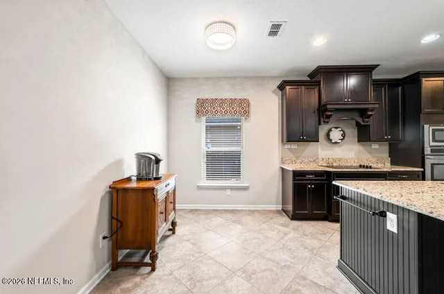 a kitchen with kitchen island granite countertop stainless steel appliances cabinets a sink and a counter top space