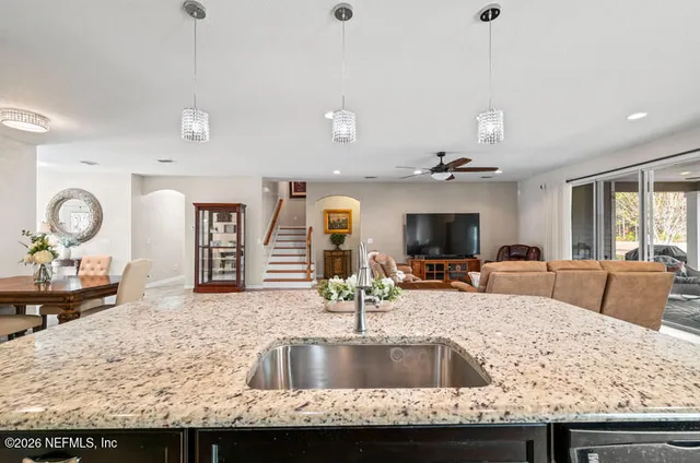 a kitchen with granite countertop a sink a counter top space appliances and cabinets