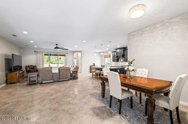 a living room with furniture and a dining table with kitchen view