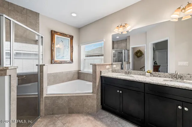 a bathroom with a tub sink and mirror