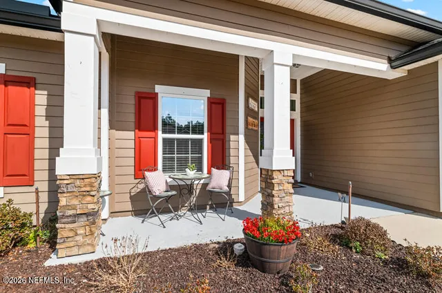 a view of a porch with chairs and potted plants