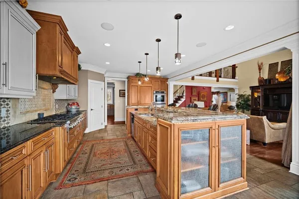 a large kitchen with stainless steel appliances granite countertop a stove and a sink