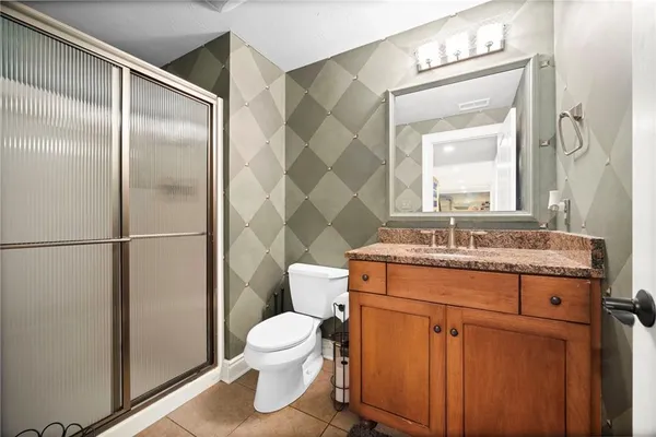 a bathroom with a granite countertop sink toilet and shower