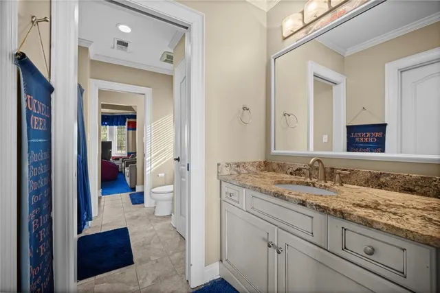a en suite bathroom with a granite countertop sink and a mirror