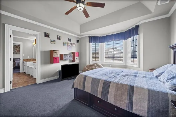a bedroom with a bed dresser and flat screen tv