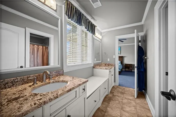 a en suite bathroom with a granite countertop sink and a mirror