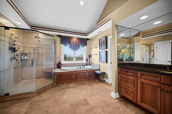 a bathroom with a tub sink shower and mirror