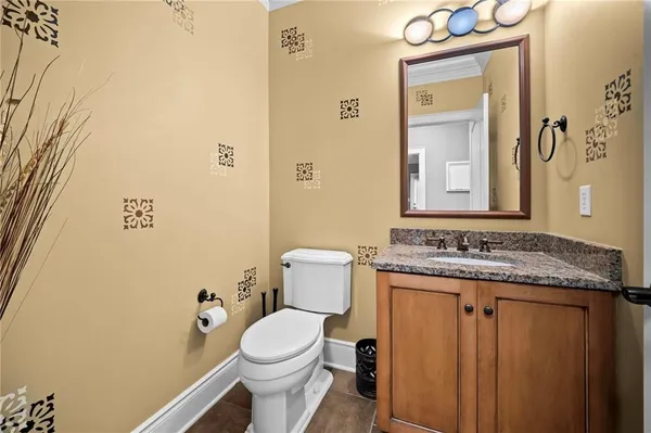 a bathroom with a granite countertop toilet and sink