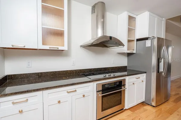 a kitchen with granite countertop a sink a counter top space and cabinets