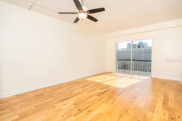 a view of empty room with wooden floor