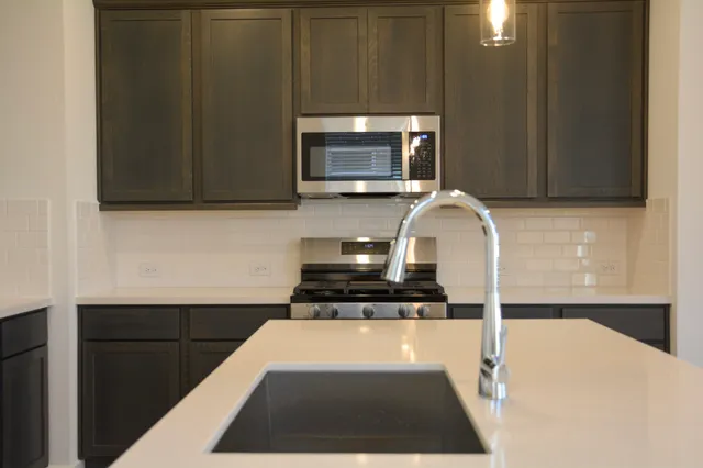 a kitchen with granite countertop a stove and a microwave