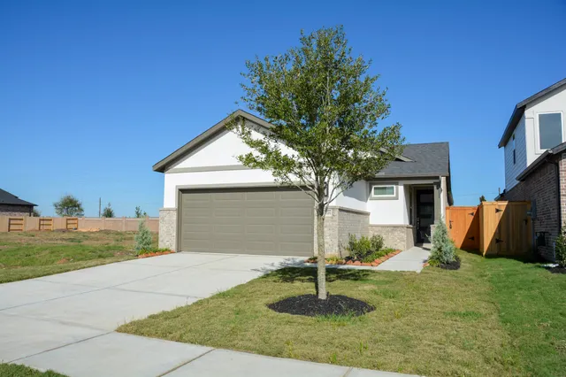 a front view of house with yard and trees in the background