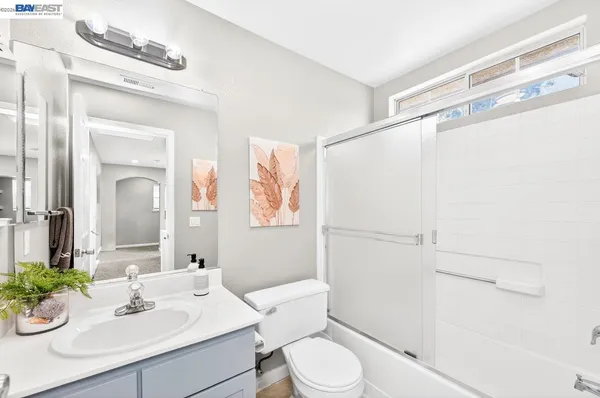 a bathroom with a sink vanity mirror and toilet