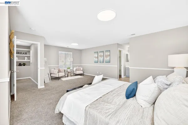 a bedroom with bed and white cabinets