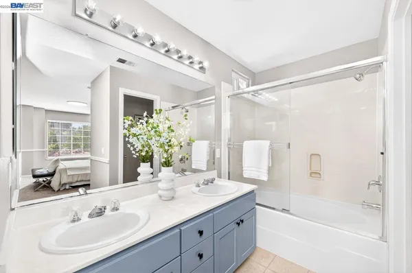 a bathroom with a tub shower sink and mirror