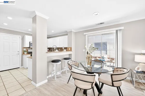 a kitchen with a dining table chairs and white cabinets