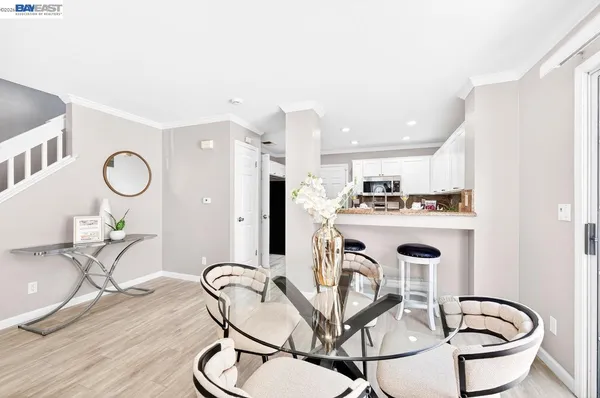 a kitchen with stainless steel appliances granite countertop a dining table chairs stove and sink