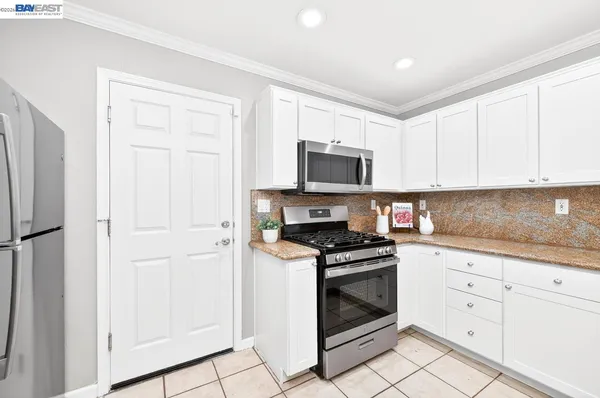 a kitchen with white cabinets and stainless steel appliances