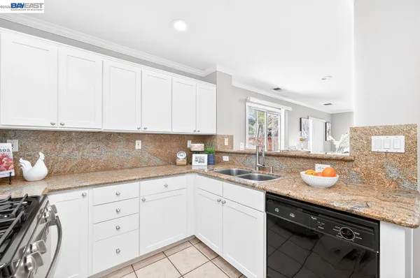 a kitchen with granite countertop white cabinets and white appliances