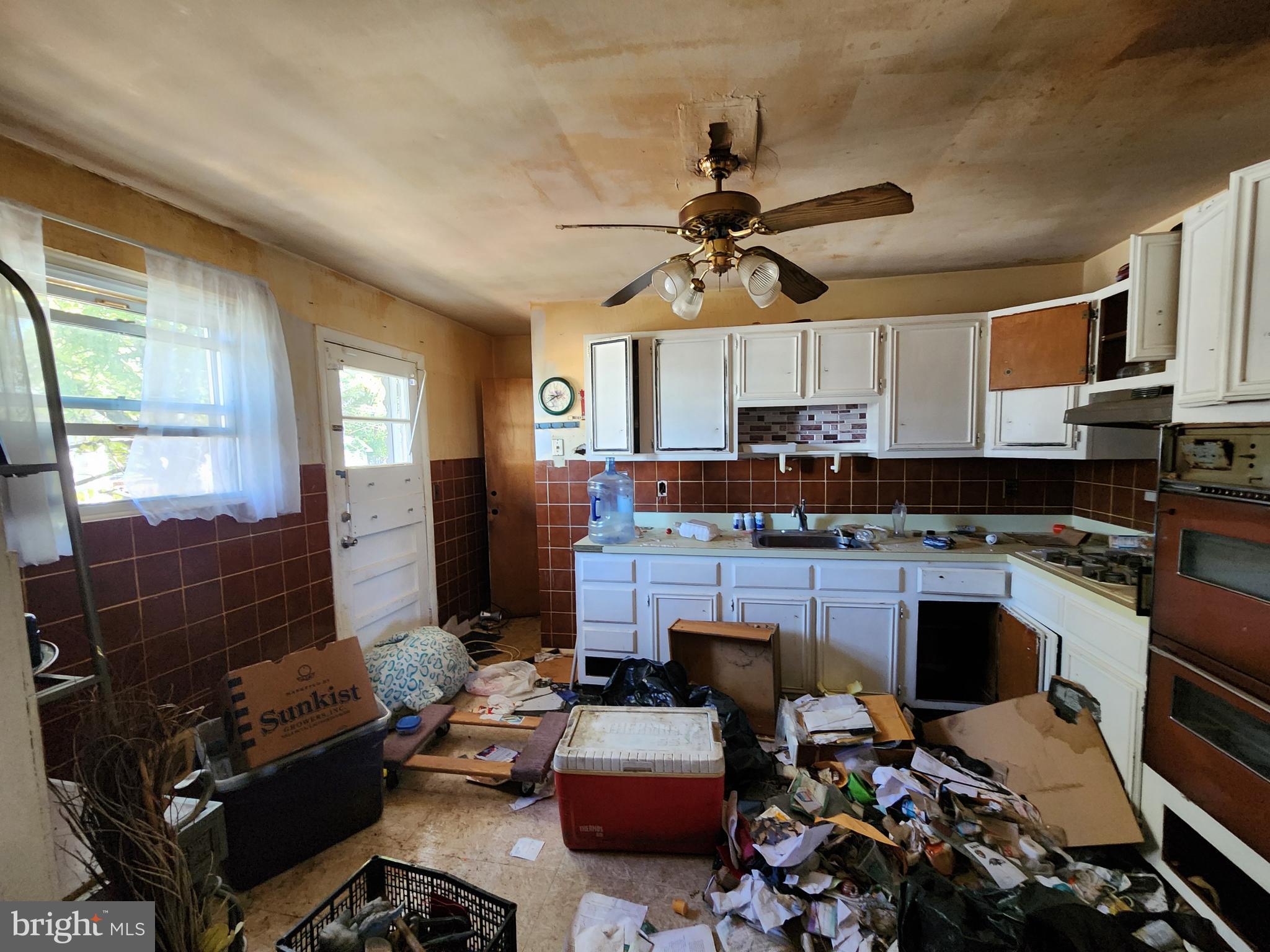6701 Bessemer Avenue Baltimore, MD 21222 - Photo 4 of 16 a kitchen with kitchen island granite countertop a sink stove and cabinets