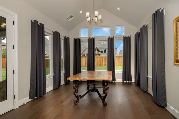 a view of a room with kitchen island stainless steel appliances wooden floor and window