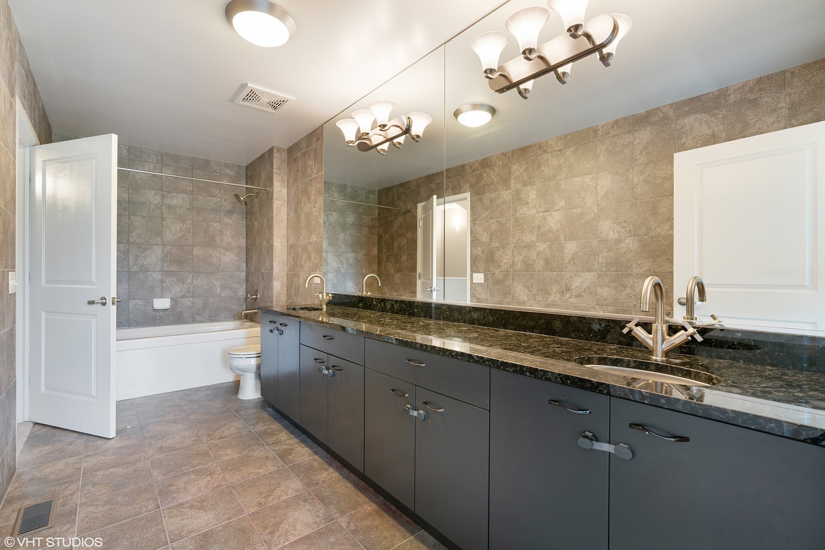 434 West Elm Street Chicago, IL 60610 - Photo 8 of 18 a bathroom with a granite countertop sink a large mirror and a bathtub with shower