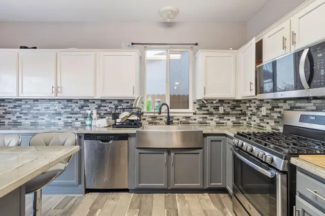 a kitchen with kitchen island granite countertop a sink stove and cabinets