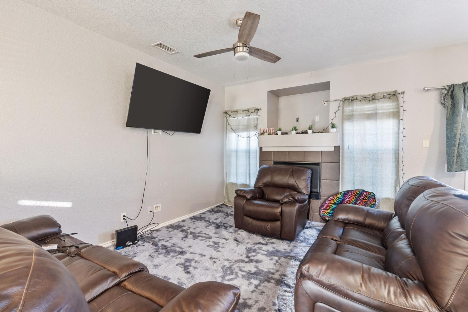 701 Palmer Place Atwater, CA 95301 - Photo 6 of 31 a living room with furniture a flat screen tv and a fireplace