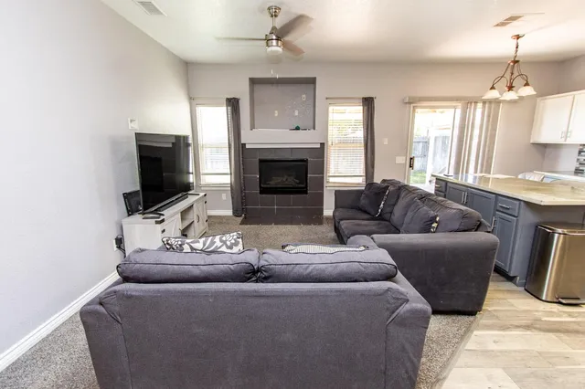 a close view of kitchen island with stainless steel appliances granite countertop refrigerator sink and cabinets
