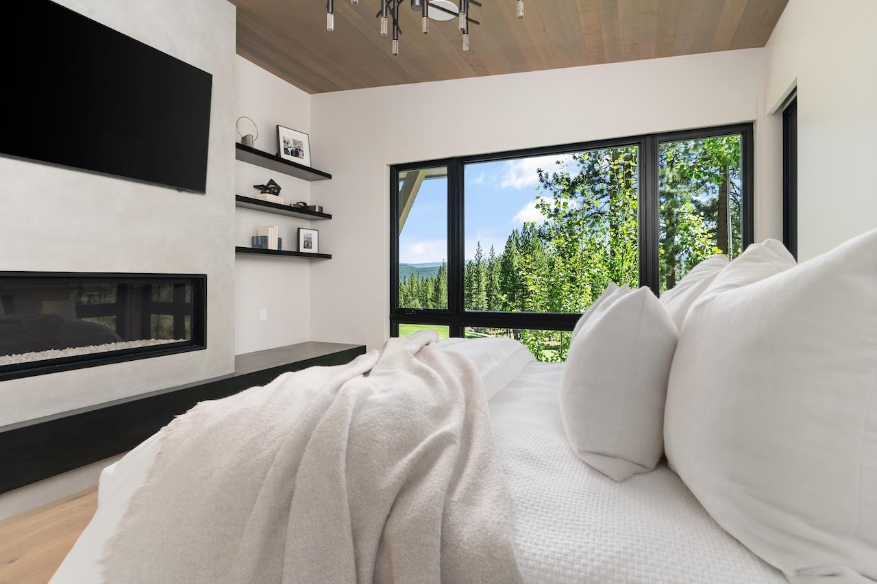 7745 Lahontan Drive Truckee, CA 96161 - Photo 10 of 28 a bed sitting in a bedroom next to a large window with a flat screen tv