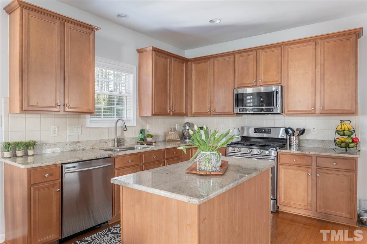8600 Churchdown Court Raleigh, NC 27613 - Photo 11 of 29 a kitchen with stainless steel appliances granite countertop a sink a stove a microwave cabinets and a window