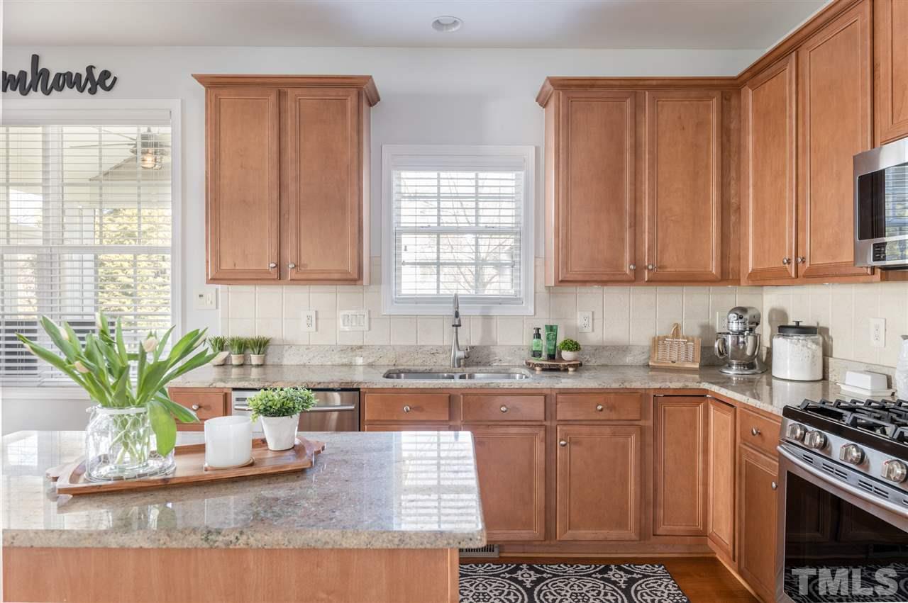 8600 Churchdown Court Raleigh, NC 27613 - Photo 12 of 29 a kitchen with stainless steel appliances granite countertop a sink a stove a microwave a counter space and cabinets