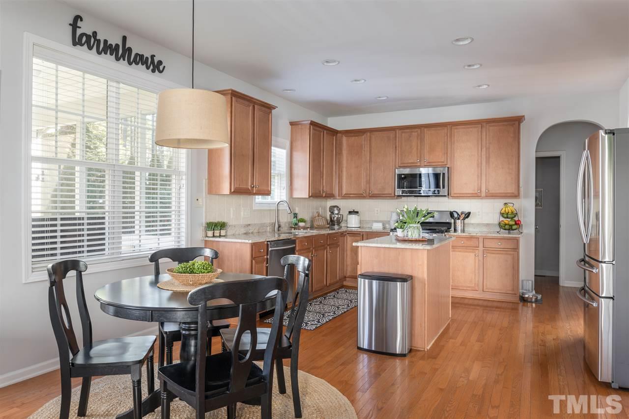 8600 Churchdown Court Raleigh, NC 27613 - Photo 13 of 29 a kitchen with a dining table chairs and refrigerator