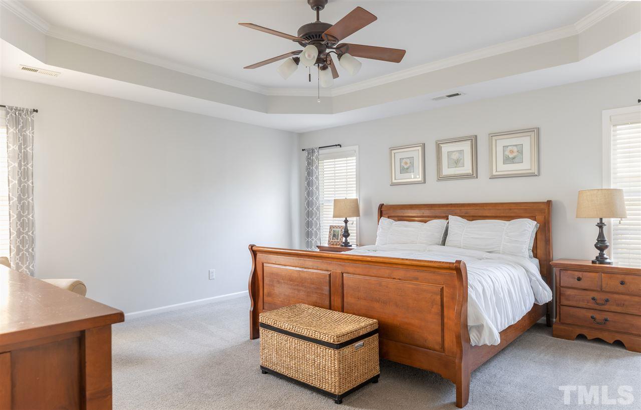 8600 Churchdown Court Raleigh, NC 27613 - Photo 15 of 29 a bedroom with a bed and a chandelier