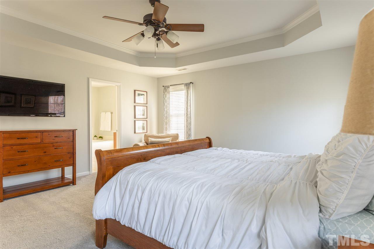 8600 Churchdown Court Raleigh, NC 27613 - Photo 17 of 29 a bedroom with a bed and a television