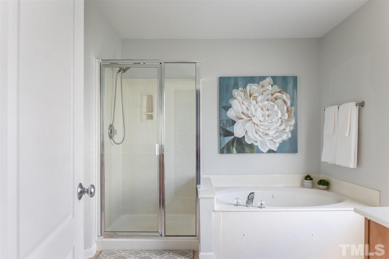 8600 Churchdown Court Raleigh, NC 27613 - Photo 18 of 29 a bathroom with a tub a sink and glass door