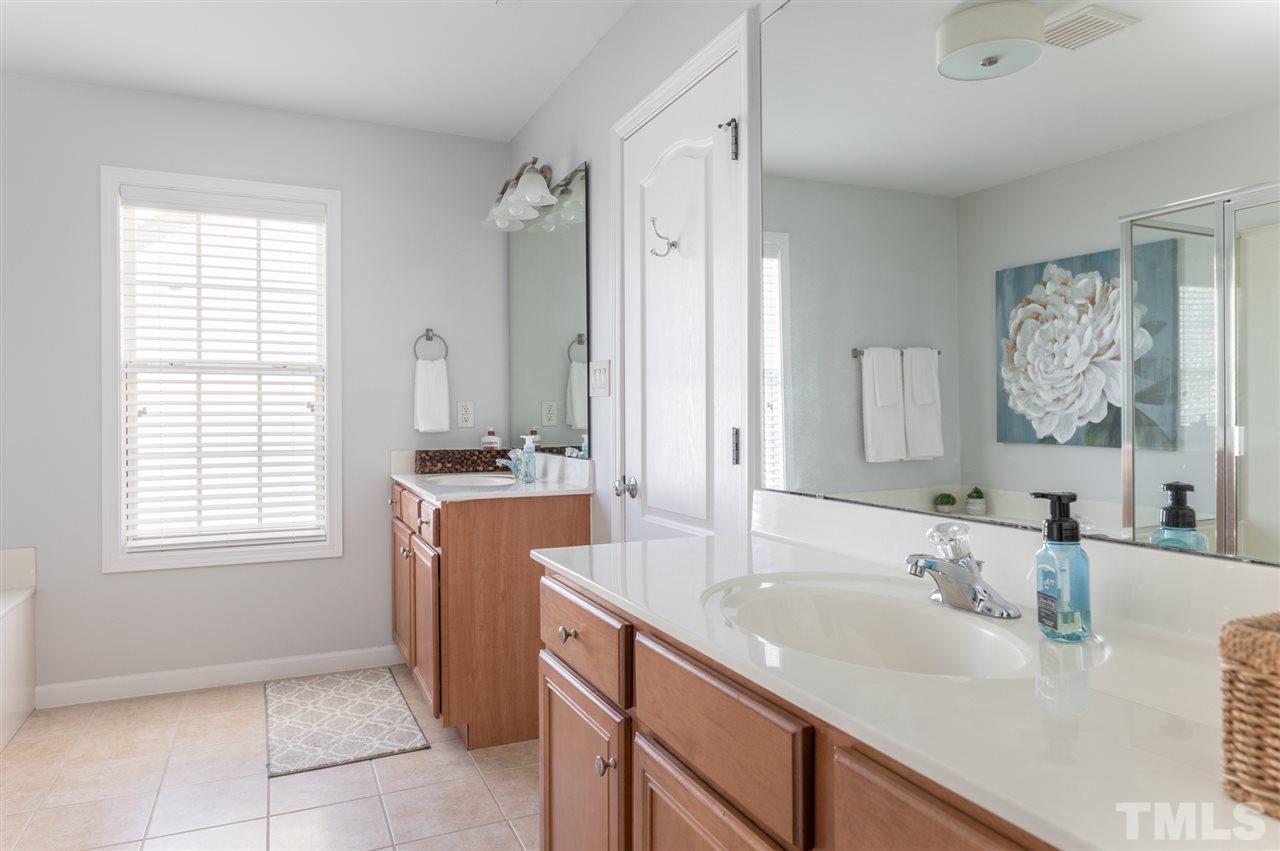 8600 Churchdown Court Raleigh, NC 27613 - Photo 19 of 29 a bathroom with a granite countertop sink and a mirror
