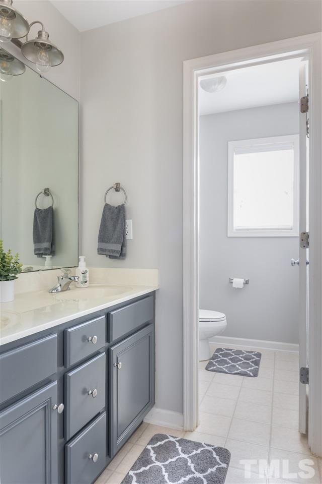 8600 Churchdown Court Raleigh, NC 27613 - Photo 26 of 29 a bathroom with a sink a toilet and a mirror