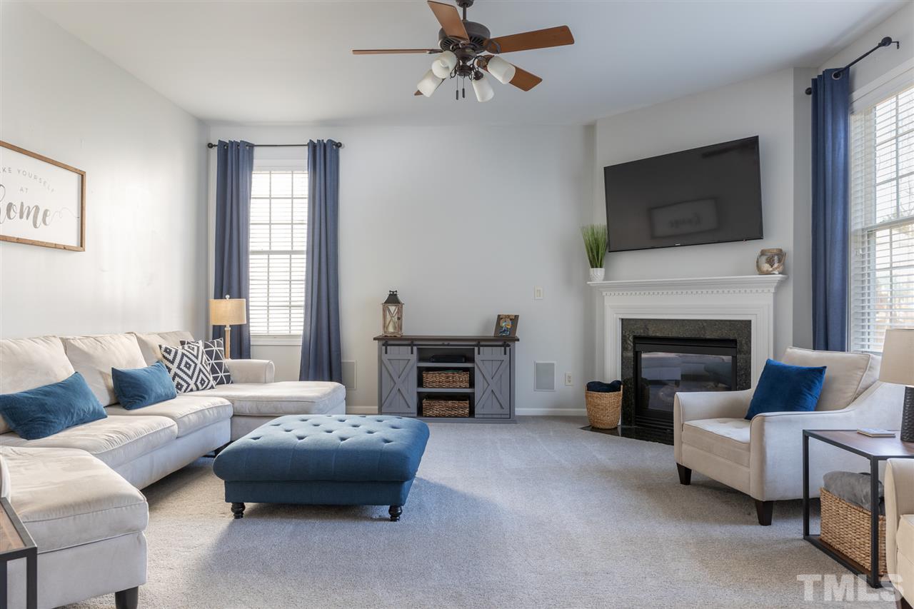 8600 Churchdown Court Raleigh, NC 27613 - Photo 10 of 29 a living room with furniture a flat screen tv and a fireplace