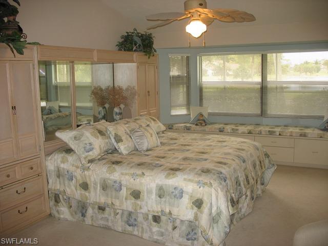 117 Muirfield Circle Naples, FL 34113 - Photo 3 of 12 a large bedroom with a bed and glass window