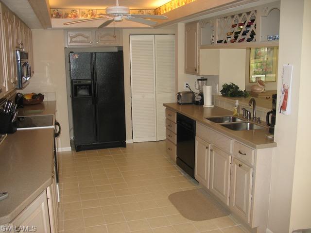 117 Muirfield Circle Naples, FL 34113 - Photo 4 of 12 a kitchen with stainless steel appliances a refrigerator and a sink