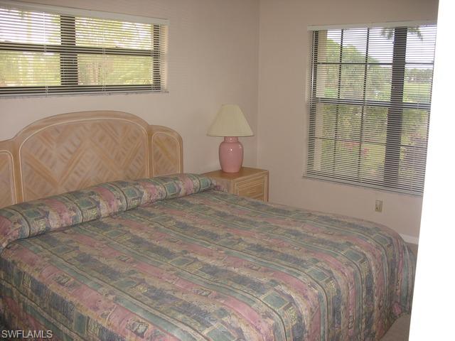 117 Muirfield Circle Naples, FL 34113 - Photo 7 of 12 a bedroom with a bed and a window