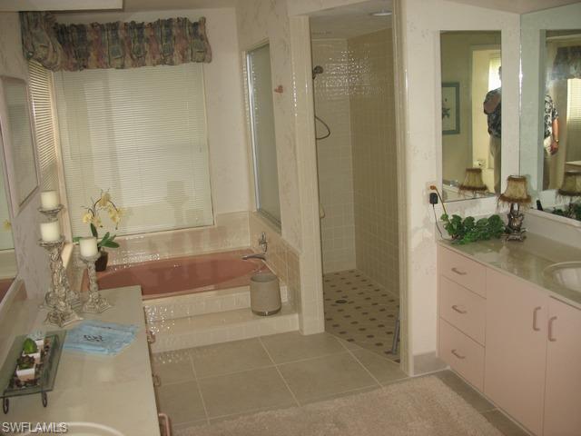 117 Muirfield Circle Naples, FL 34113 - Photo 8 of 12 a bathroom with a granite countertop bathtub sink and toilet