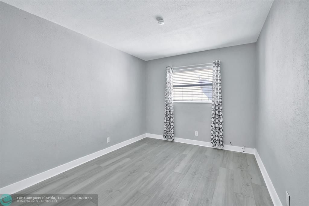 2741 Northeast 8th Avenue, Unit 15 Wilton Manors, FL 33334 - Photo 11 of 46 an empty room with wooden floor and windows