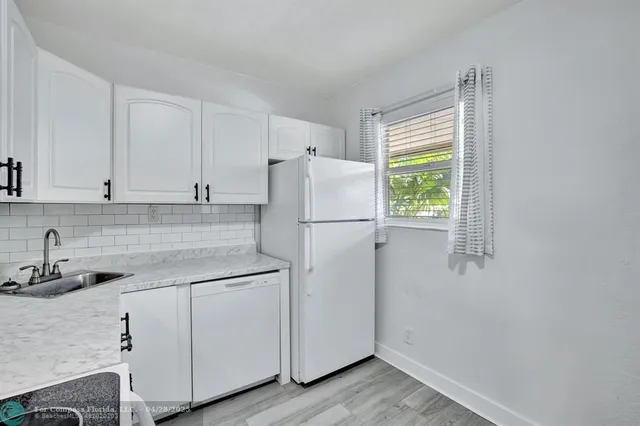 a white refrigerator freezer sitting inside of a kitchen