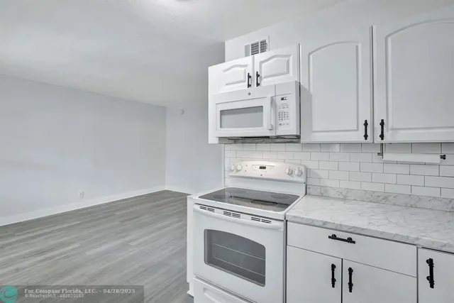 a kitchen with cabinets appliances and a counter space
