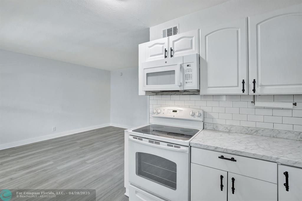 2741 Northeast 8th Avenue, Unit 15 Wilton Manors, FL 33334 - Photo 3 of 46 a kitchen with cabinets appliances and a counter space